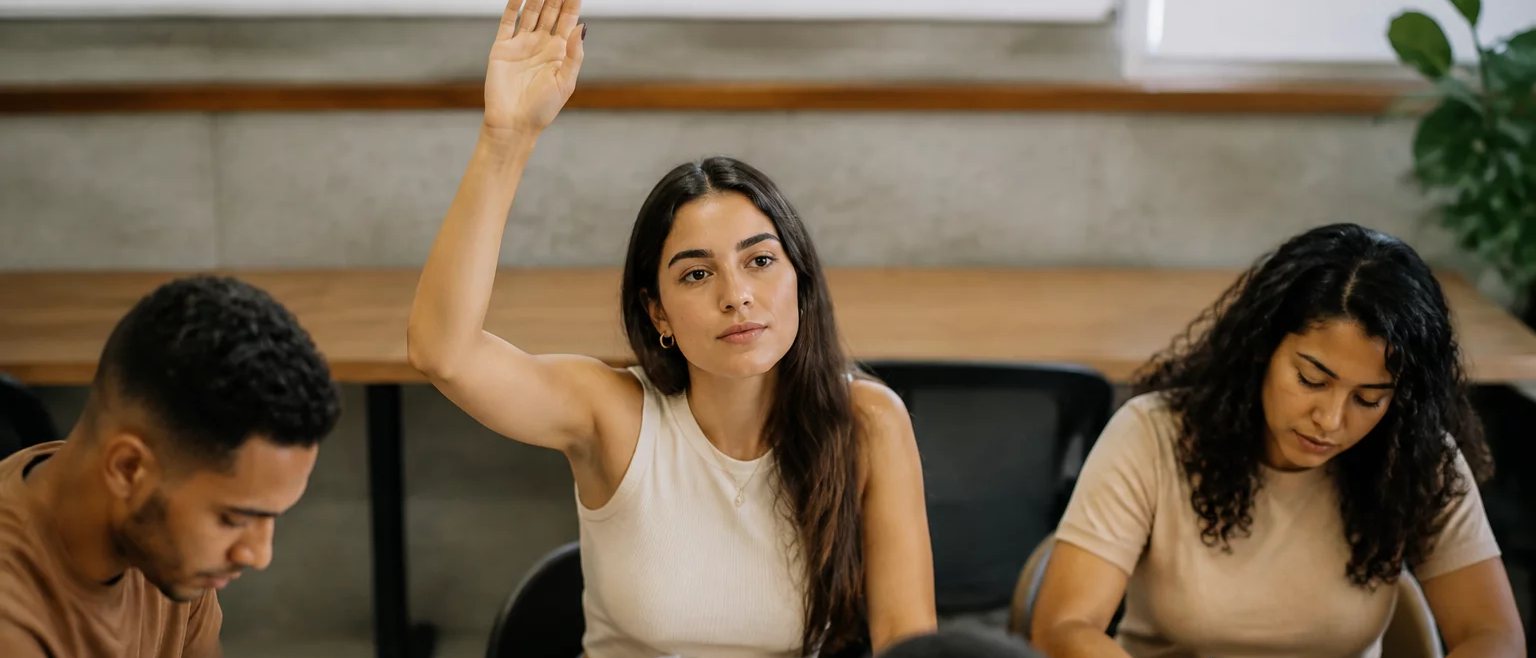 A sala fotografada de longe depois da última rodada, com papéis e canetas sobre a mesa comprida